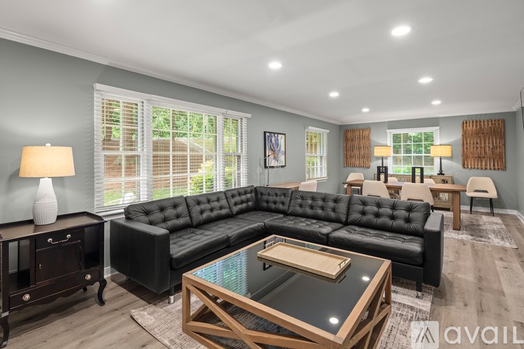 A living room with a black leather sofa and a wooden coffee table.