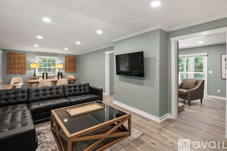 A modern living room with a black leather sofa and a wooden coffee table.