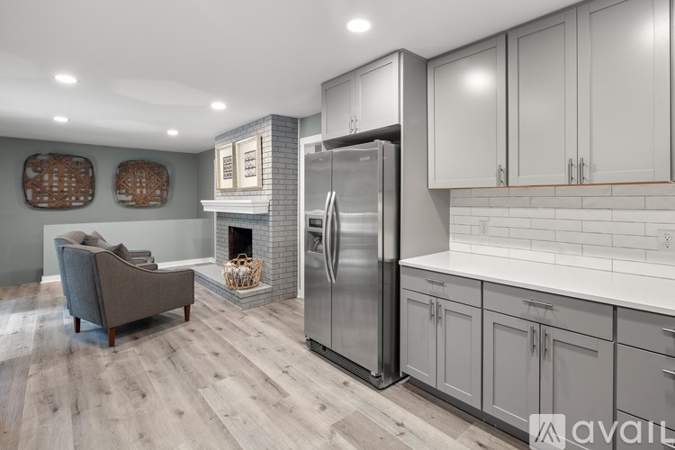 A modern kitchen with a grey chair and a fireplace.