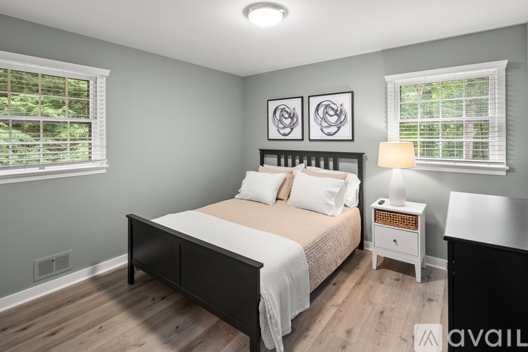 A bedroom with a bed, nightstand, and two wall art pieces.