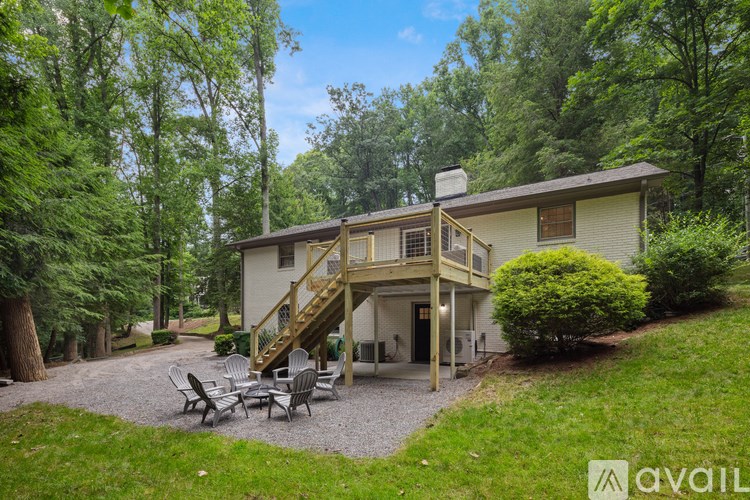 A house with a patio and a deck surrounded by trees.