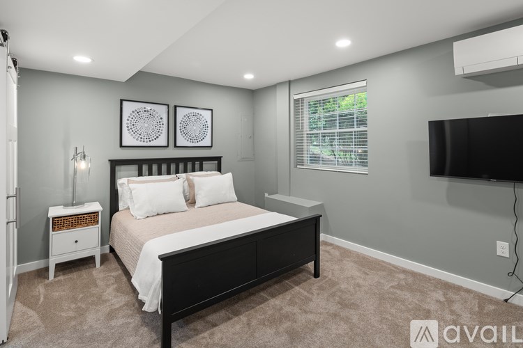 A bedroom with a bed, nightstand, and a television.