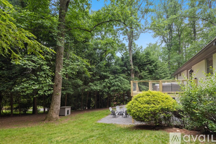 A lush green backyard with a house and trees.