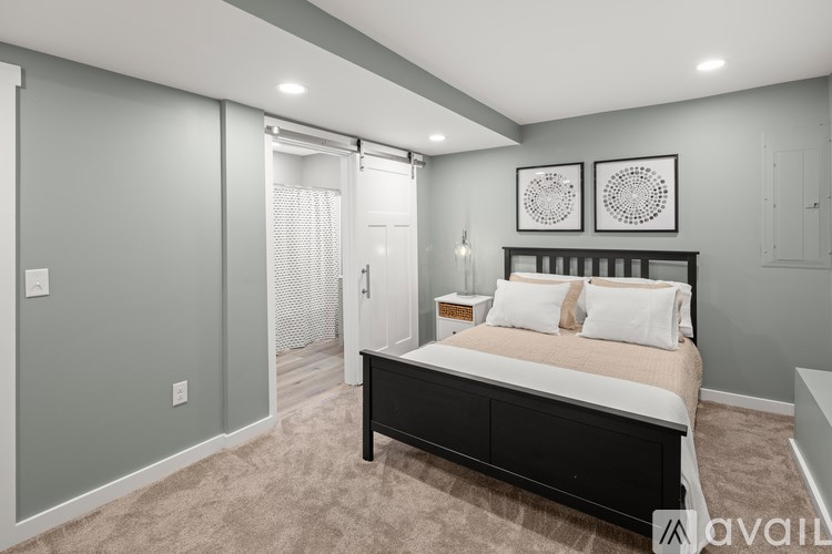 A bedroom with a bed, two pillows, and two wall art pieces.