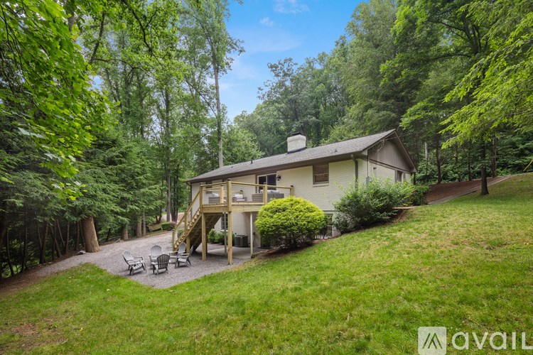A house with a deck and a patio surrounded by trees.