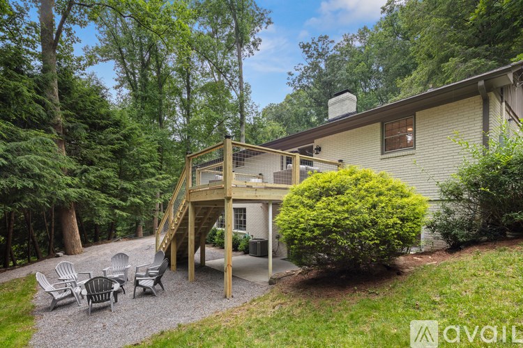 A house with a deck and a patio surrounded by trees.