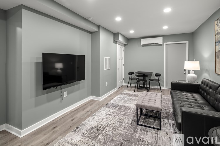 A modern living room with a flat screen TV mounted on the wall.