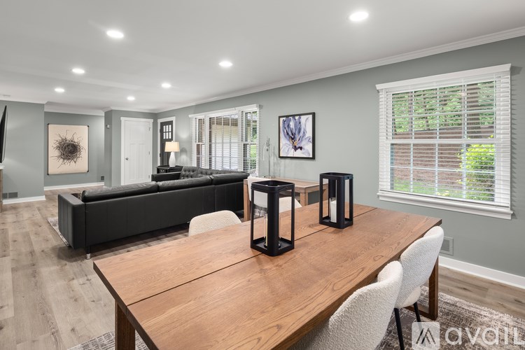 A modern dining room with a wooden table and chairs.