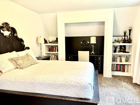 A bedroom with a large bed and a fireplace.