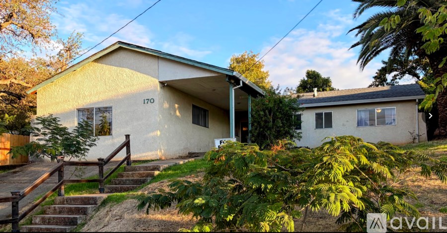 A house with the number 170 on it is surrounded by greenery.