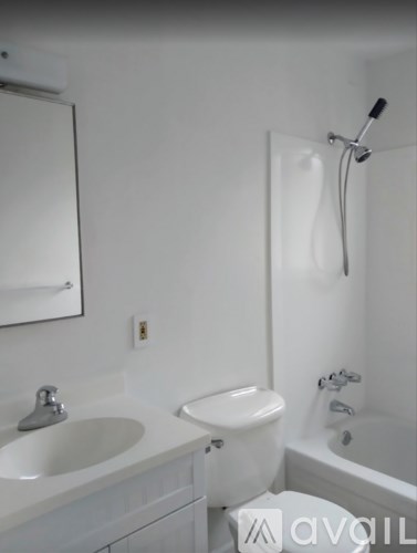 A white bathroom with a sink, toilet, and bathtub.