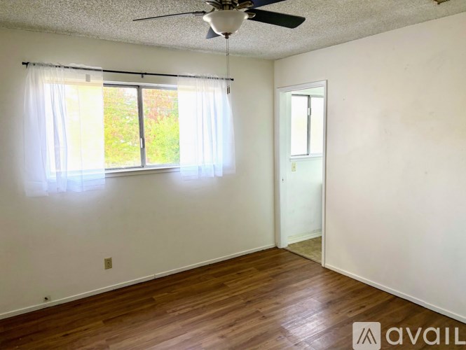 A room with a ceiling fan and a door leading to another room.