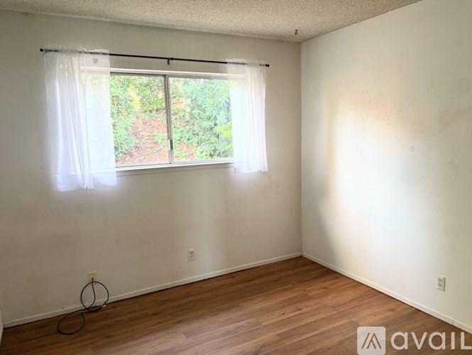 A room with a window and a bicycle wheel on the floor.