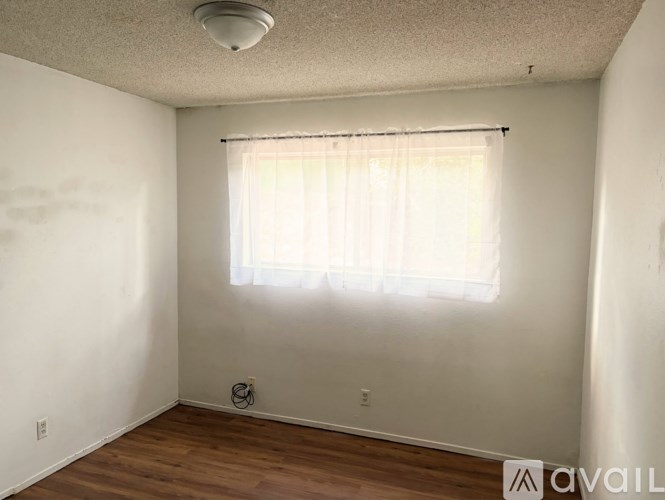 A room with a window covered by a white curtain.