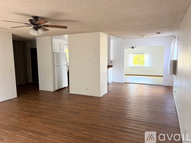 A room with wooden floors and a ceiling fan.