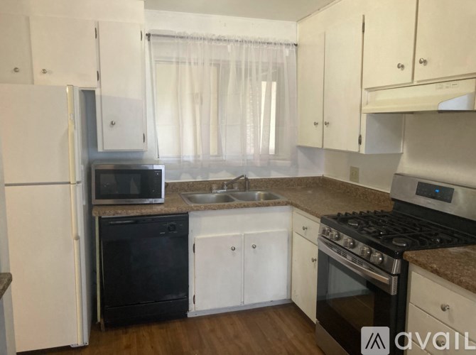 A kitchen with white cabinets and a black oven.