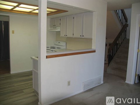 A kitchen area with white cabinets and a stove top oven.