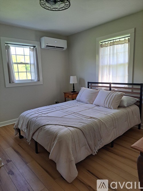 A bedroom with a bed, nightstand, and window.