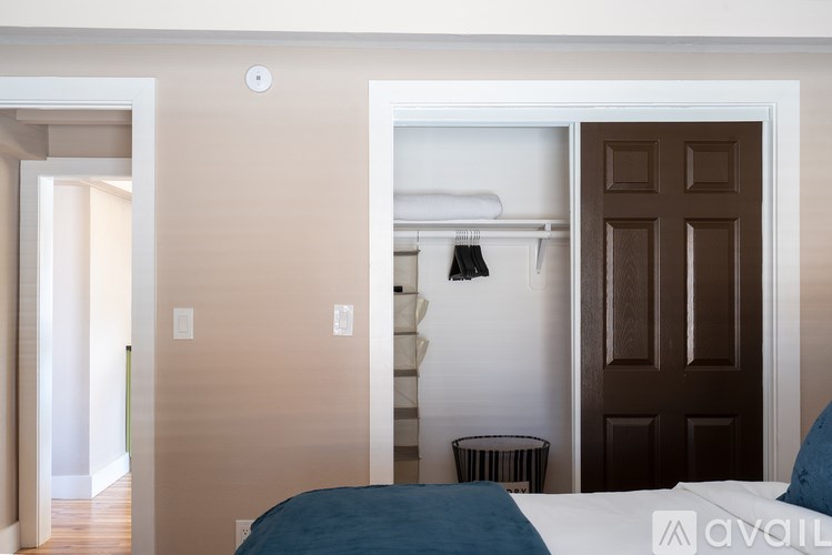 A bedroom with a bed, a wardrobe, and a door.