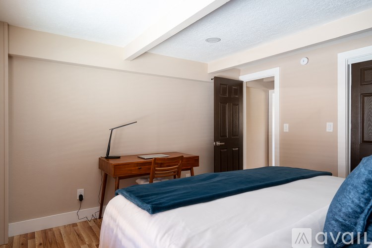 A bedroom with a bed, desk, and chair.