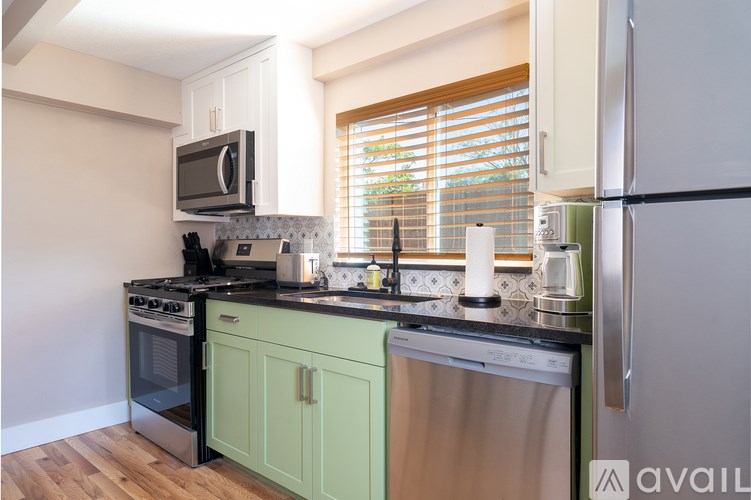 A kitchen with a green cabinet and a stainless steel dishwasher.
