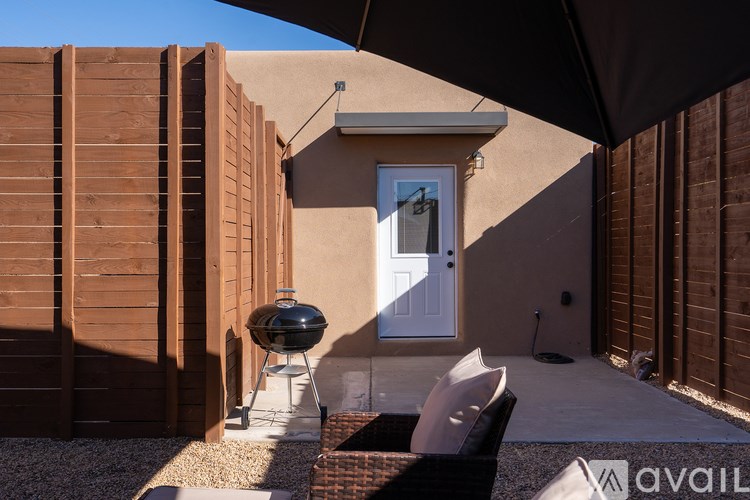 A patio area with a grill and a table.