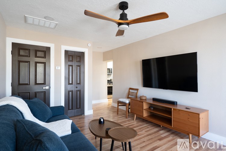 A living room with a couch, a chair, a coffee table, and a television.