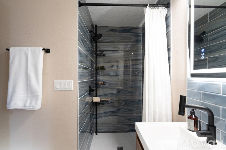 A white towel hangs on a towel rack in a bathroom.