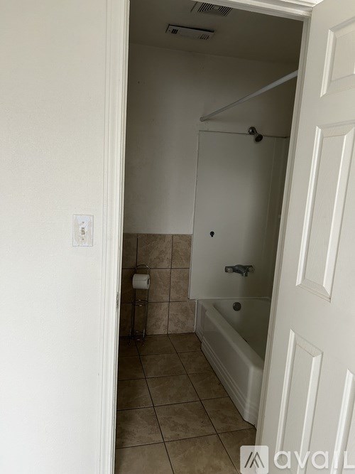 A bathroom with a toilet, a tub, and a towel rack.