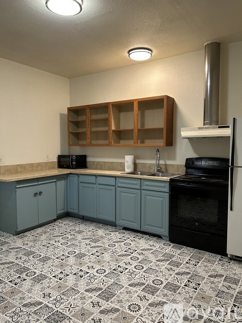 A kitchen with a black oven and a black refrigerator.