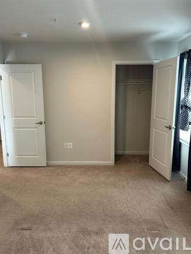 A room with a white door and a carpeted floor.