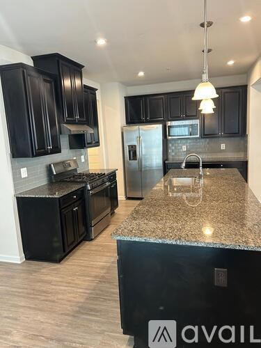 A kitchen with black cabinets and granite countertops.
