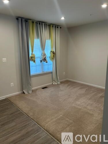 A room with a window and curtains.