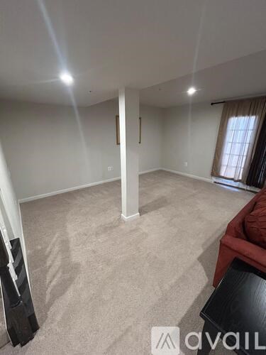 A living room with a red couch and a black chair.