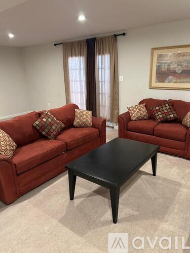 Two red couches with pillows and a black coffee table in a room.