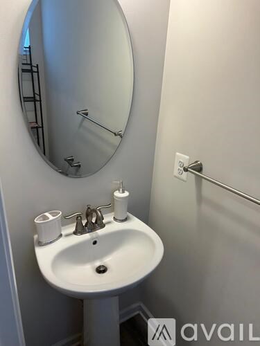 A white sink with a round mirror above it.