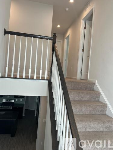 A staircase with a black railing and a white balustrade.