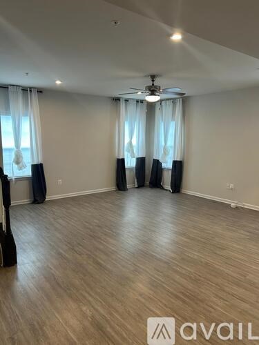 A room with wooden flooring and a ceiling fan.