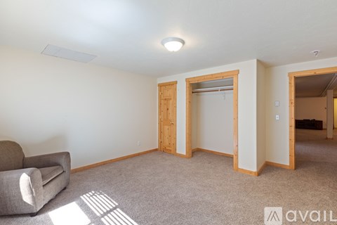 A living room with a grey sofa and a carpet.