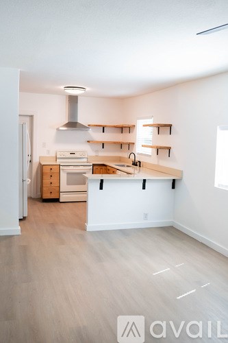 A kitchen with a white counter and wooden floors.