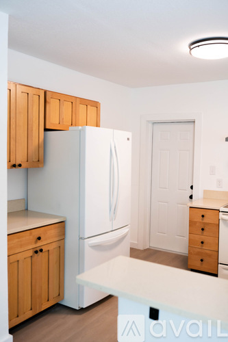 A kitchen with wooden cabinets and a white fridge.