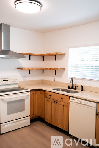 A kitchen with wooden cabinets and a white oven.