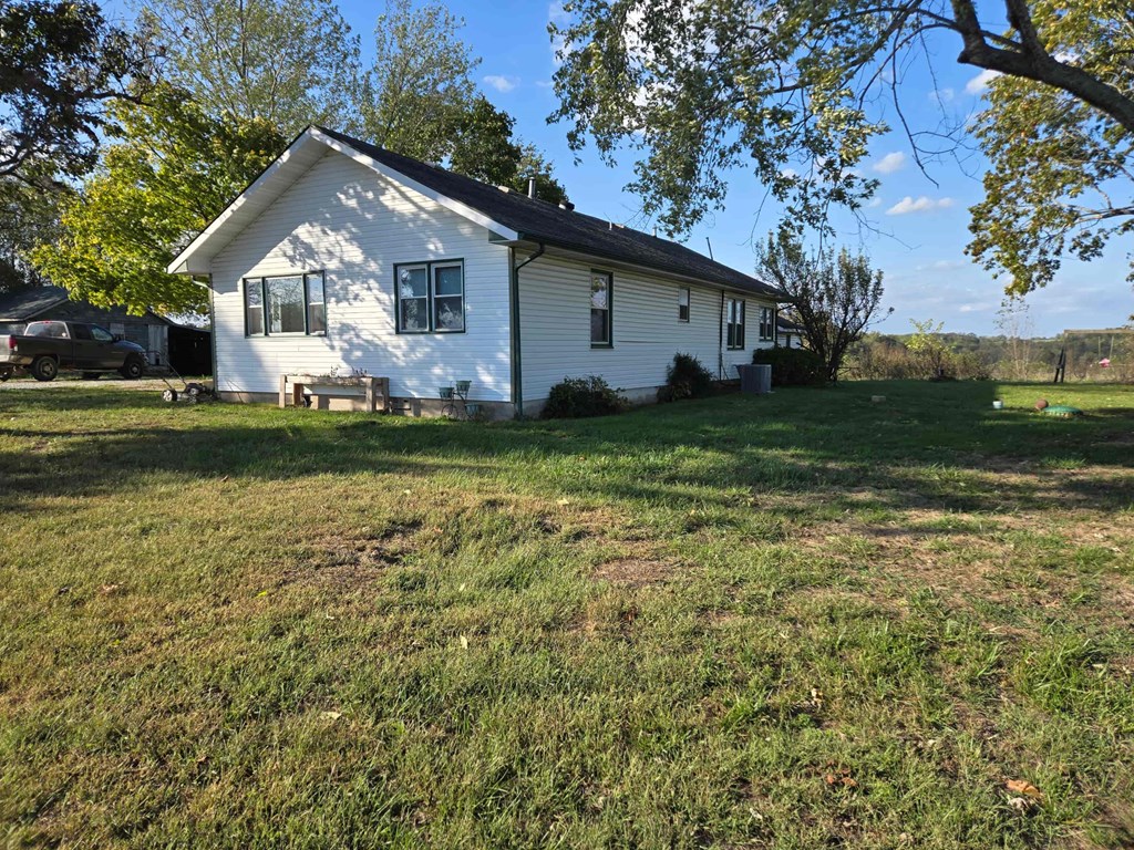 A white house with a green lawn in front.