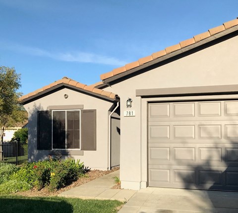 a house with a garage door and a driveway in front of it