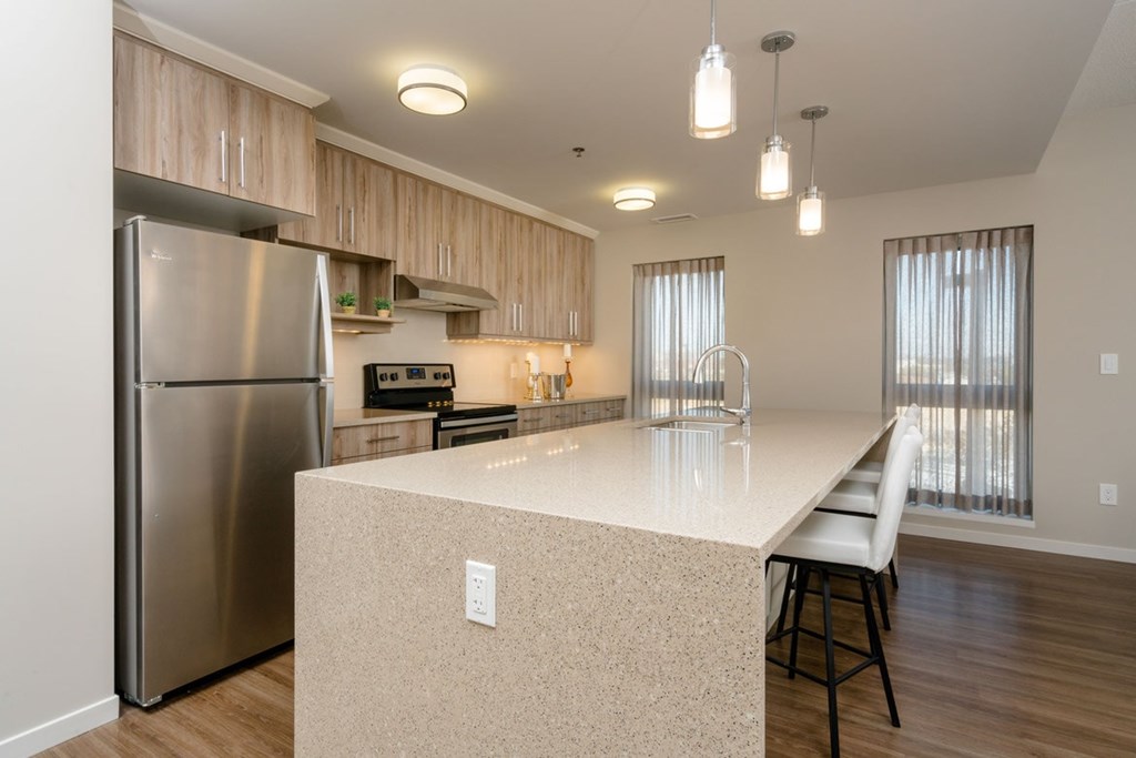 A kitchen with a stainless steel refrigerator and a white countertop.