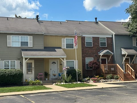 A row of houses with a flag on the third one.