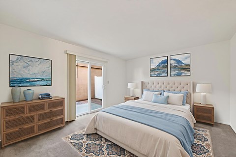 A bedroom with a large bed and a wooden dresser.