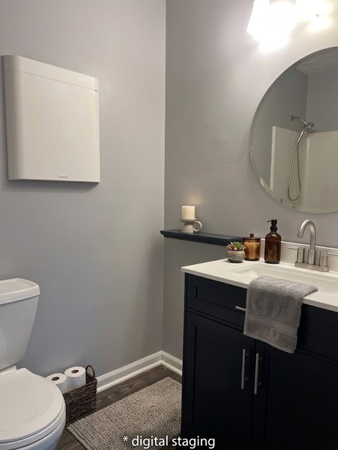 A bathroom with a toilet, sink, and mirror.