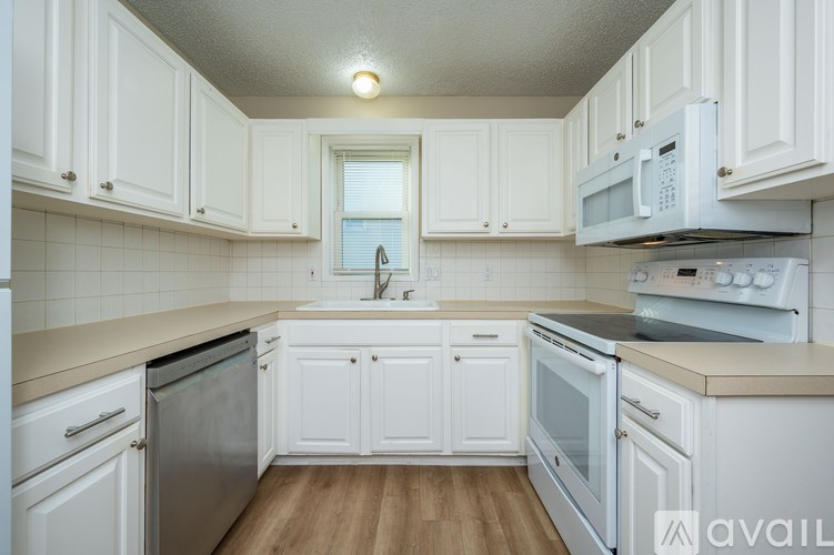 A kitchen with white cabinets and appliances.