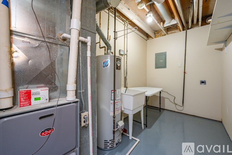 A room with a water heater and a tank.